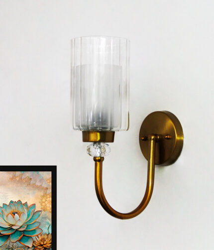Wall Sconce with clear ribbed glass cylinder shade and gold curved arm mounted on a white wall