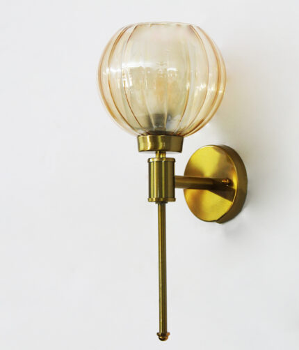 Brass wall light with amber ribbed glass globe shade mounted on a wall, featuring a sleek gold finish and modern decorative design