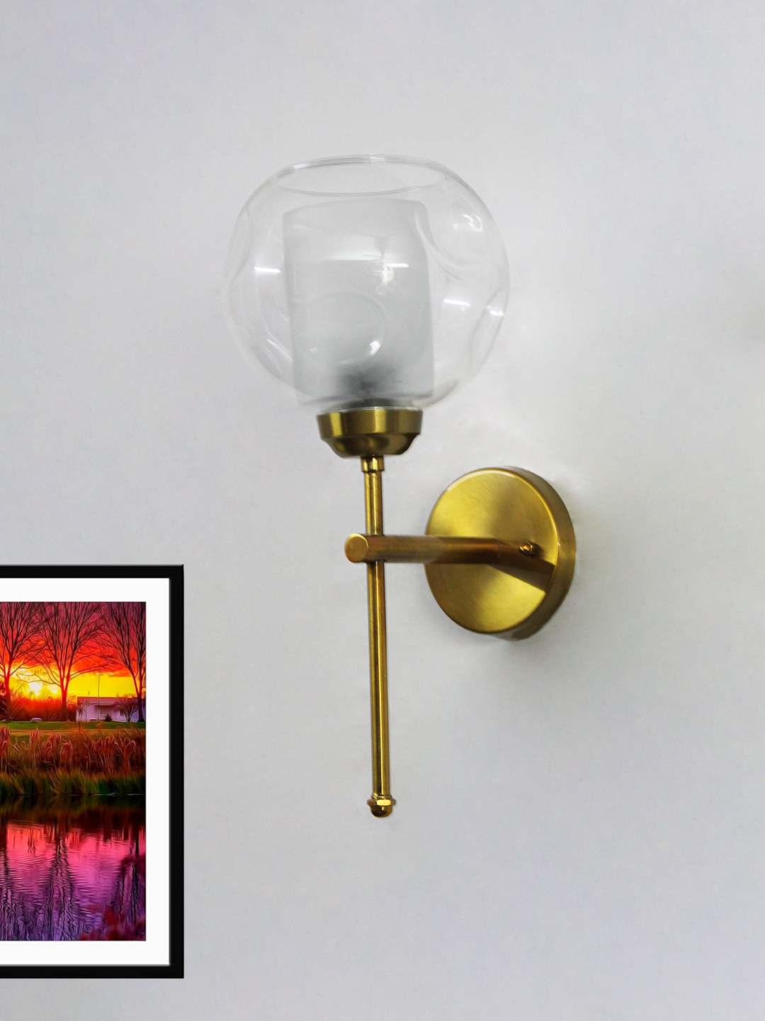 Contemporary Brass Wall Light Clear Glass Contemporary Brass Wall Light with clear glass shade mounted on a white wall, featuring a sleek gold finish and modern minimalist design.