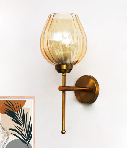 Amber Glass Lamp wall light with textured amber glass shade and brass finish, mounted on a white wall, giving a warm and cozy glow.