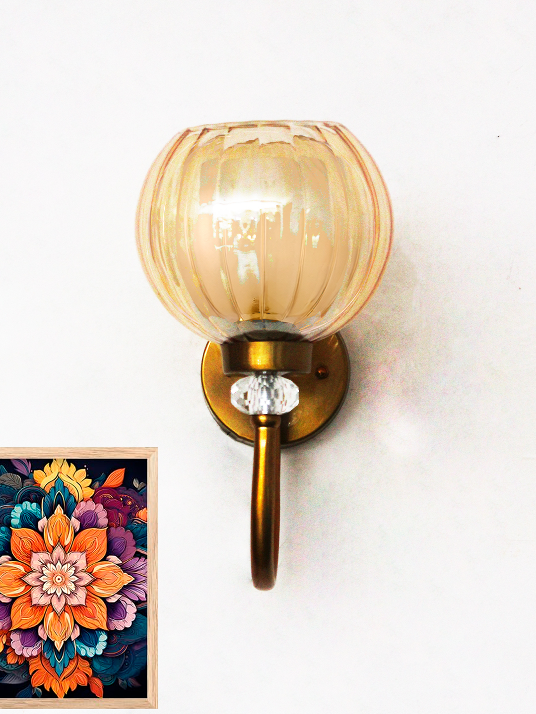 Decorative Brass Wall Light with Amber Glass Globe Amber Glass Globe wall sconce with ribbed glass shade and gold curved arm glowing warmly on a white wall