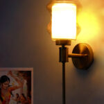 Lamp Amber Glass wall light with sculpted amber shade and brass finish, featuring a vertical stem design and warm ambient illumination