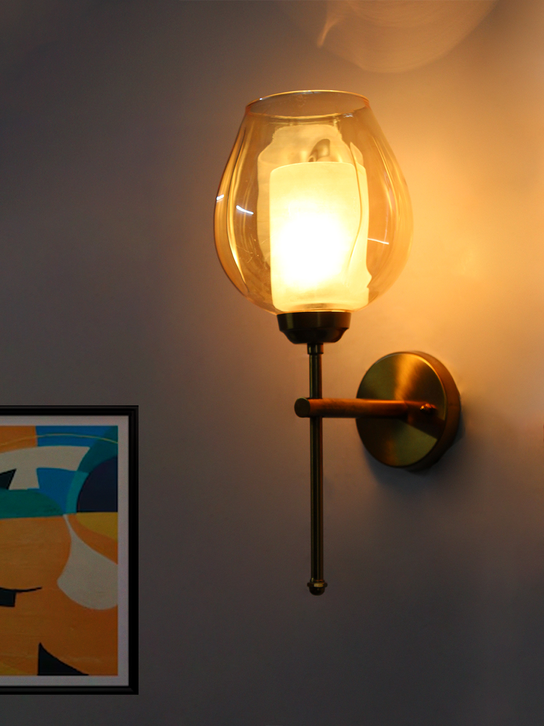 Designer Brass Wall Sconce Amber Glass Lighting Modern wall sconce with amber glass shade and gold metal base, providing warm ambient lighting on a clean minimalist interior wall.