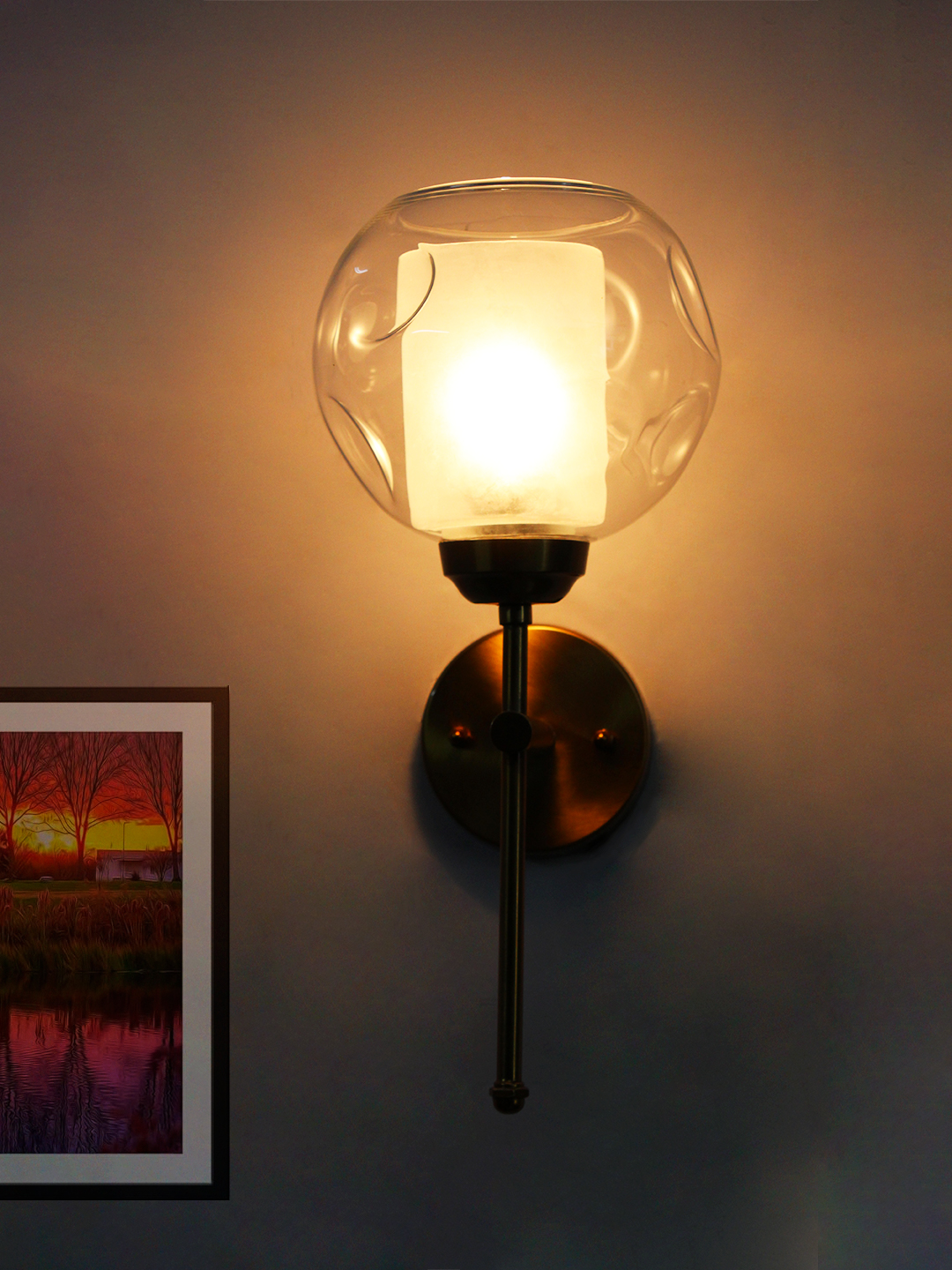 Contemporary Brass Wall Light Clear Glass Contemporary Brass Wall Light with clear glass shade mounted on a white wall, featuring a sleek gold finish and modern minimalist design.