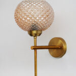 Amber Crystal Globe Glass wall light with textured diamond-pattern glass shade and brushed brass mount on white background