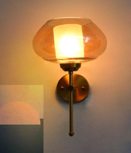 Amber Kachori Glass wall light with smooth curved amber glass shade and brushed brass mount on white background