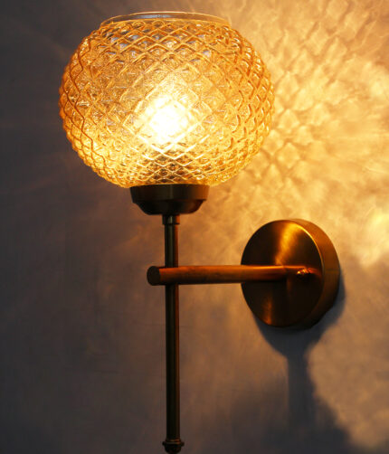 Amber Crystal Globe Glass wall light with textured diamond-pattern glass shade and brushed brass mount on white background