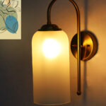 White Milky Froasted Glass wall light with cylindrical frosted glass shade and curved brass arm mounted on wall