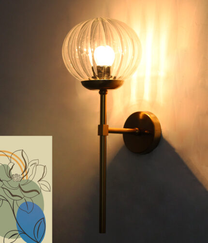 Clear Kharbuja Glass wall light with ribbed transparent glass globe and brass mount on white wall