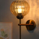 Amber Kharbhuja Glass wall light with ribbed amber glass shade and brushed brass mount on white background