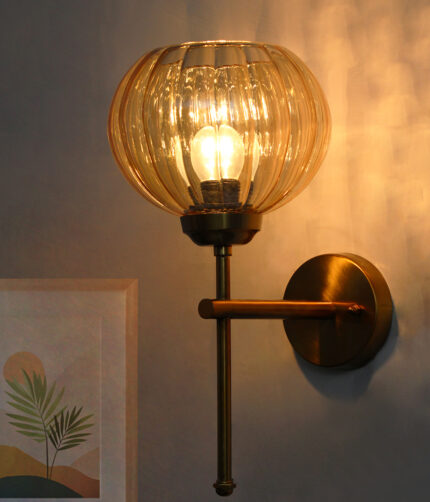 Amber Kharbhuja Glass wall light with ribbed amber glass shade and brushed brass mount on white background