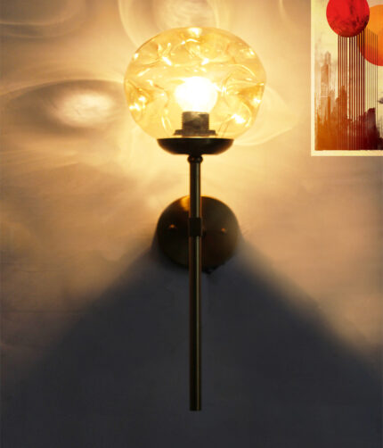 Amber Glass Globe Modern Light wall fixture with textured amber glass globe and brass arm mounted on white wall
