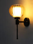 Amber Kharbuja Glass wall light with ribbed amber glass globe shade and matte black metal wall mount for elegant modern indoor lighting
