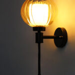 Amber Kharbuja Glass wall light with ribbed amber glass globe shade and matte black metal wall mount for elegant modern indoor lighting