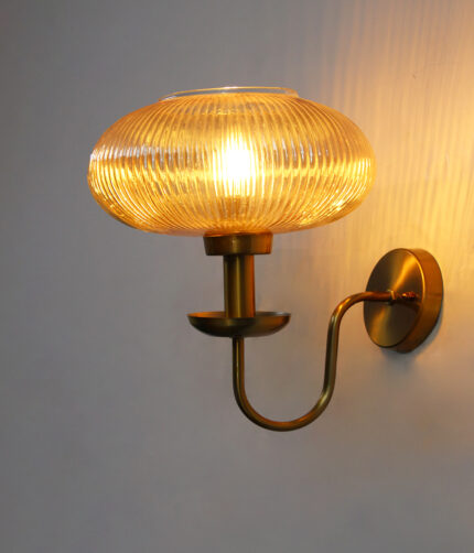 Kachori Amber Glass Wall Lamp with ribbed amber glass shade and antique brass curved arm for bedroom, living room, and hallway décor