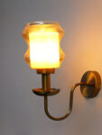 Damru Glass Wall Sconce with amber designer glass shade and brass finish curved arm decorative wall lamp for bedroom and living room