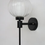 Clear Kharbuja Glass wall light with clear ribbed glass globe shade and matte black metal wall mount for elegant modern indoor lighting