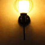 Amber Kharbuja Glass wall light with ribbed amber glass globe shade and matte black metal wall mount for elegant modern indoor lighting