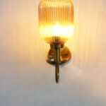 Amber Glass Curved Arm Wall Lamp with ribbed glass shade and antique brass finish for bedroom, living room, and hallway décor