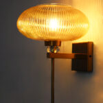 Kachori Glass Wall Light with amber ribbed glass shade, brass finish wall mount, decorative crystal accent and modern vintage wall sconce design