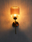 Amber Ribbed Glass Wall Lamp with ribbed amber glass shade and brass finish metal wall mount for elegant modern indoor lighting