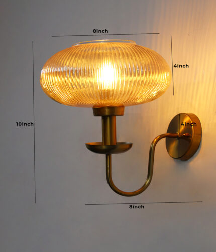 Kachori Amber Glass Wall Lamp with ribbed amber glass shade and antique brass curved arm for bedroom, living room, and hallway décor