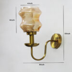 Damru Glass Wall Sconce with amber designer glass shade and brass finish curved arm decorative wall lamp for bedroom and living room
