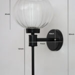 Clear Kharbuja Glass wall light with clear ribbed glass globe shade and matte black metal wall mount for elegant modern indoor lighting