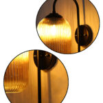 Amber Ribbed Glass wall lamp with amber ribbed cylindrical glass shade and matte black curved metal wall mount for elegant modern indoor lighting