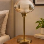 Amber Kachori Vintage table lamp with rounded amber glass shade and brass base, providing warm decorative lighting for bedside or living room use