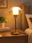 Amber Kachori Vintage table lamp with rounded amber glass shade and brass base, providing warm decorative lighting for bedside or living room use