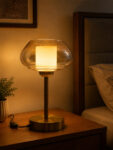 Amber Kachori Vintage table lamp with rounded amber glass shade and brass base, providing warm decorative lighting for bedside or living room use