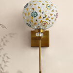 White Tipni Colourful Glass wall light with mosaic dome shade, floral and geometric patterns, and brass finish arm for decorative ambient lighting