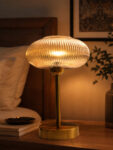 Aurora Ribbed Glass table lamp with wide ribbed amber glass shade and brass base, modern decorative lighting for bedside or living room use