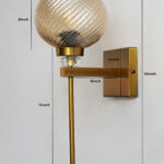 Doom MF Amber Glass wall light with ribbed dome-shaped amber glass shade, brass finish arm, and elegant vertical rod for decorative interior lighting