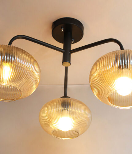 Ribbed Glass Chandelier with three amber ribbed glass shades and a matte black metal frame, modern semi-flush ceiling light for dining room, living room, and kitchen.