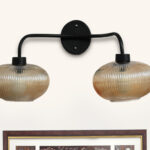 **Alt Text:** **2-Light Ribbed Glass** wall light with dual amber ribbed glass shades and a matte black metal frame, modern wall-mounted fixture for bedrooms, hallways, living rooms, and dining spaces.