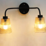 Florence Ribbed Glass dual-light wall sconce with textured ribbed glass shades and a matte black metal frame, perfect for modern bedrooms, hallways, living rooms, and dining spaces.