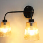 Florence Ribbed Glass dual-light wall sconce with textured ribbed glass shades and a matte black metal frame, perfect for modern bedrooms, hallways, living rooms, and dining spaces.