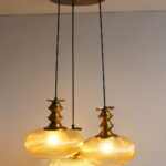 Ribbed Amber Kachori Glass 3-light adjustable pendant ceiling light with three rounded textured amber ribbed glass shades, elegant golden metal holders, 9-inch ceiling canopy, and 23-inch adjustable hanging cords.