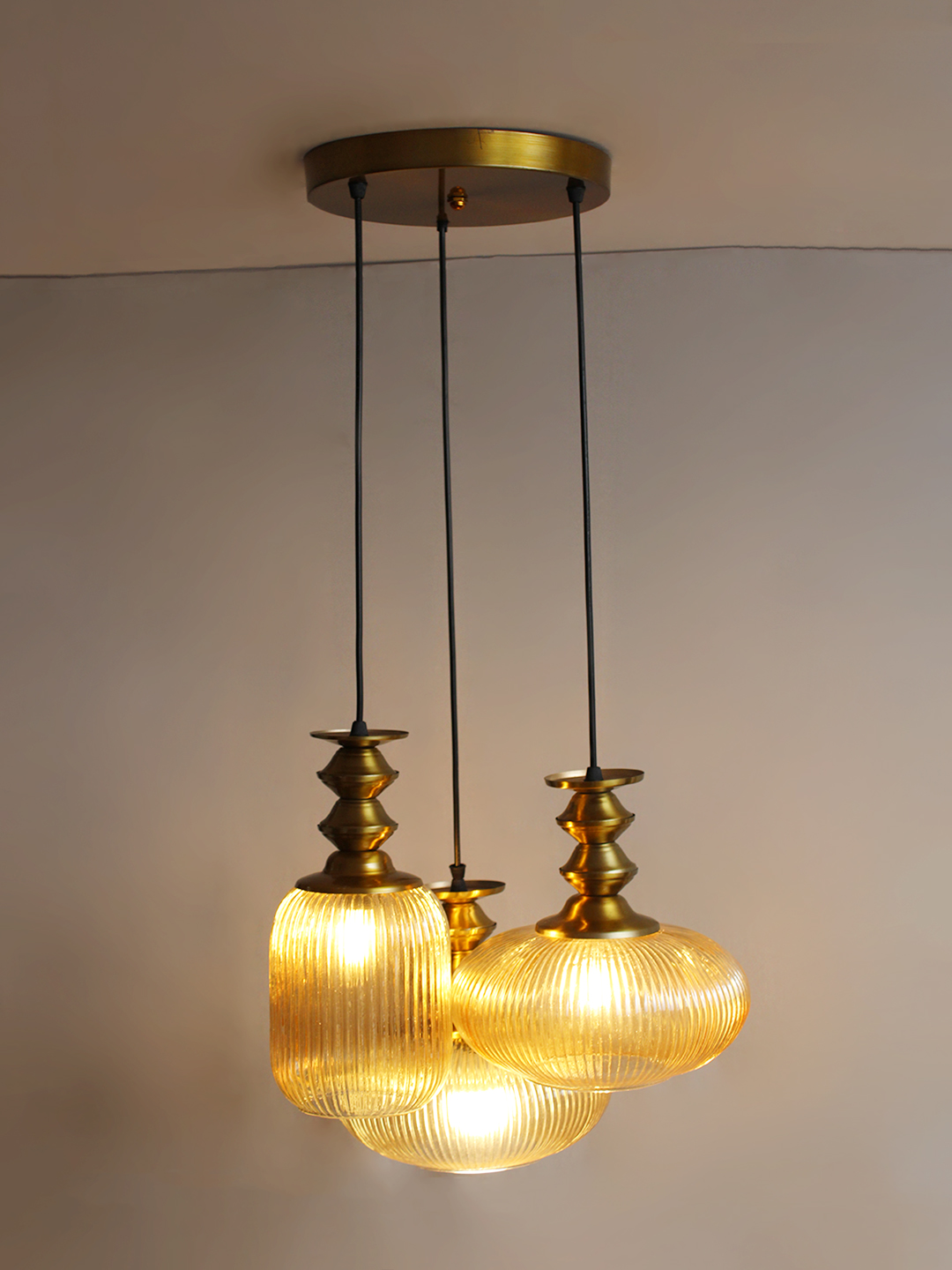 Modern Ribbed Glass Cluster Hanging Light Ribbed Modern Ribbed Glass 3-light adjustable pendant ceiling light featuring three textured ribbed glass shades in different shapes, elegant golden metal holders, black hanging cords, 9-inch canopy, and up to 23-inch adjustable height.