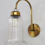 Antique brass fluted glass wall light with curved arm and decorative textured glass shade