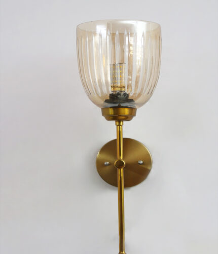 Antique brass wall light with amber ribbed glass shade and curved arm, shown with product dimensions.