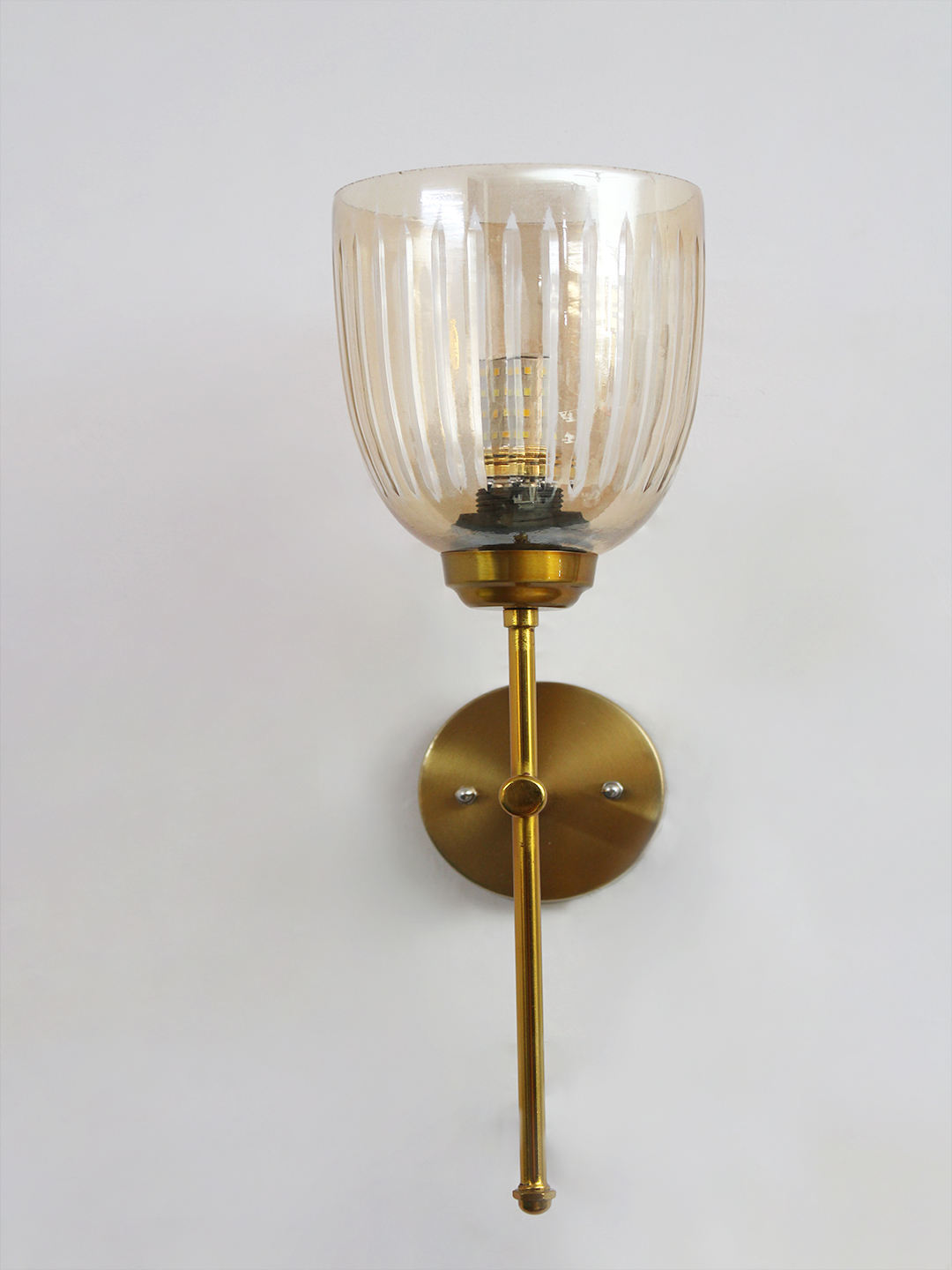 Antique Brass Fluted Glass Wall Sconce Antique brass wall light with amber ribbed glass shade and curved arm, shown with product dimensions.