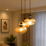 Amber Ribbed Glass cluster hanging light with four textured glass pendant shades, black metal fittings, and layered design for modern interior lighting.