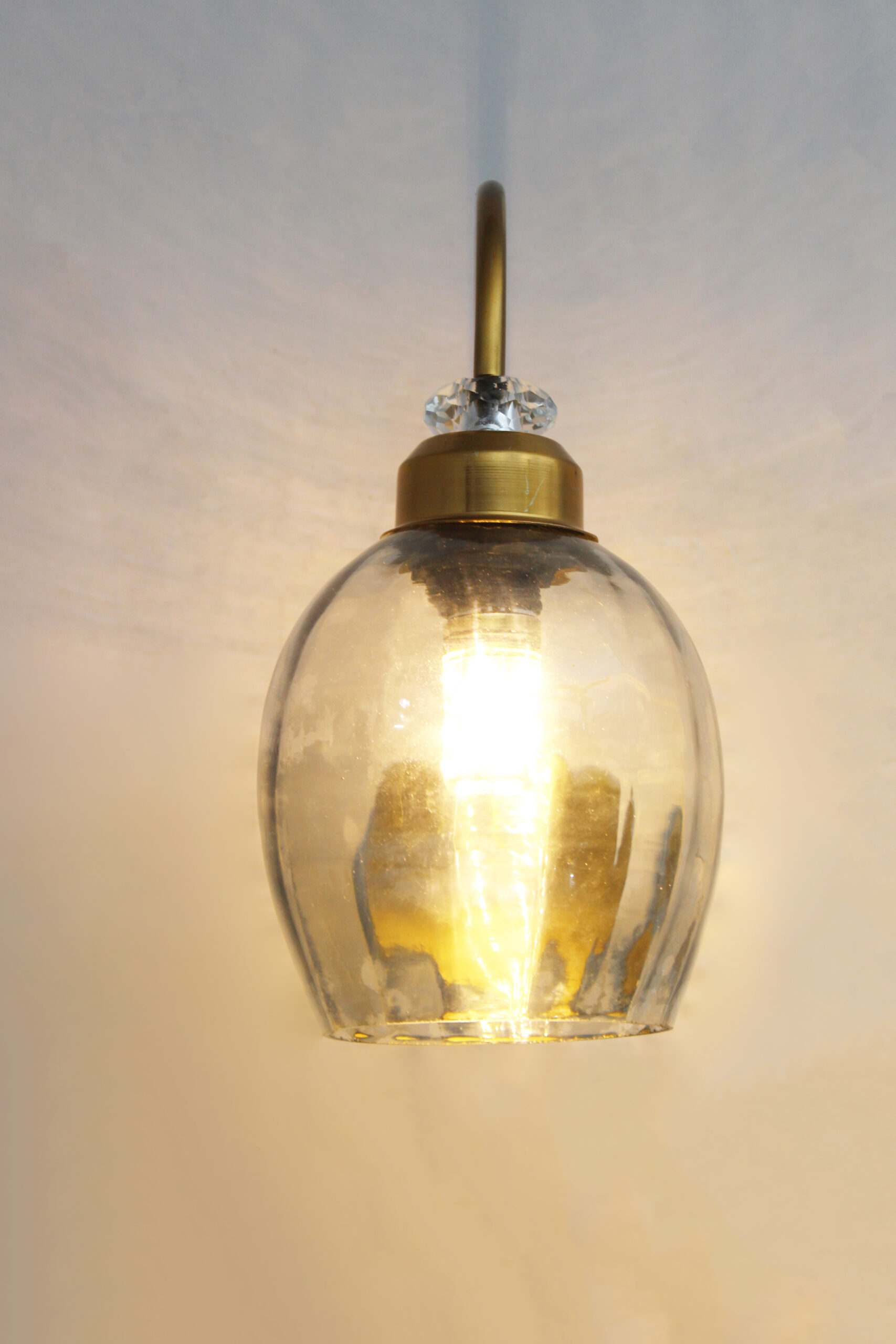 Antique Brass Smoked Glass Wall Sconce Antique brass smoked glass wall light with curved arm and round wall mount