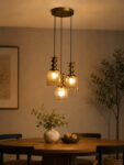 Ribbed Glass 3-Light adjustable pendant ceiling light with three textured glass shades, golden metal accents, black adjustable cords, 9-inch canopy, and elegant modern hanging design.