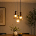 Ribbed Glass 3-Light adjustable pendant ceiling light with three textured glass shades, golden metal accents, black adjustable cords, 9-inch canopy, and elegant modern hanging design.