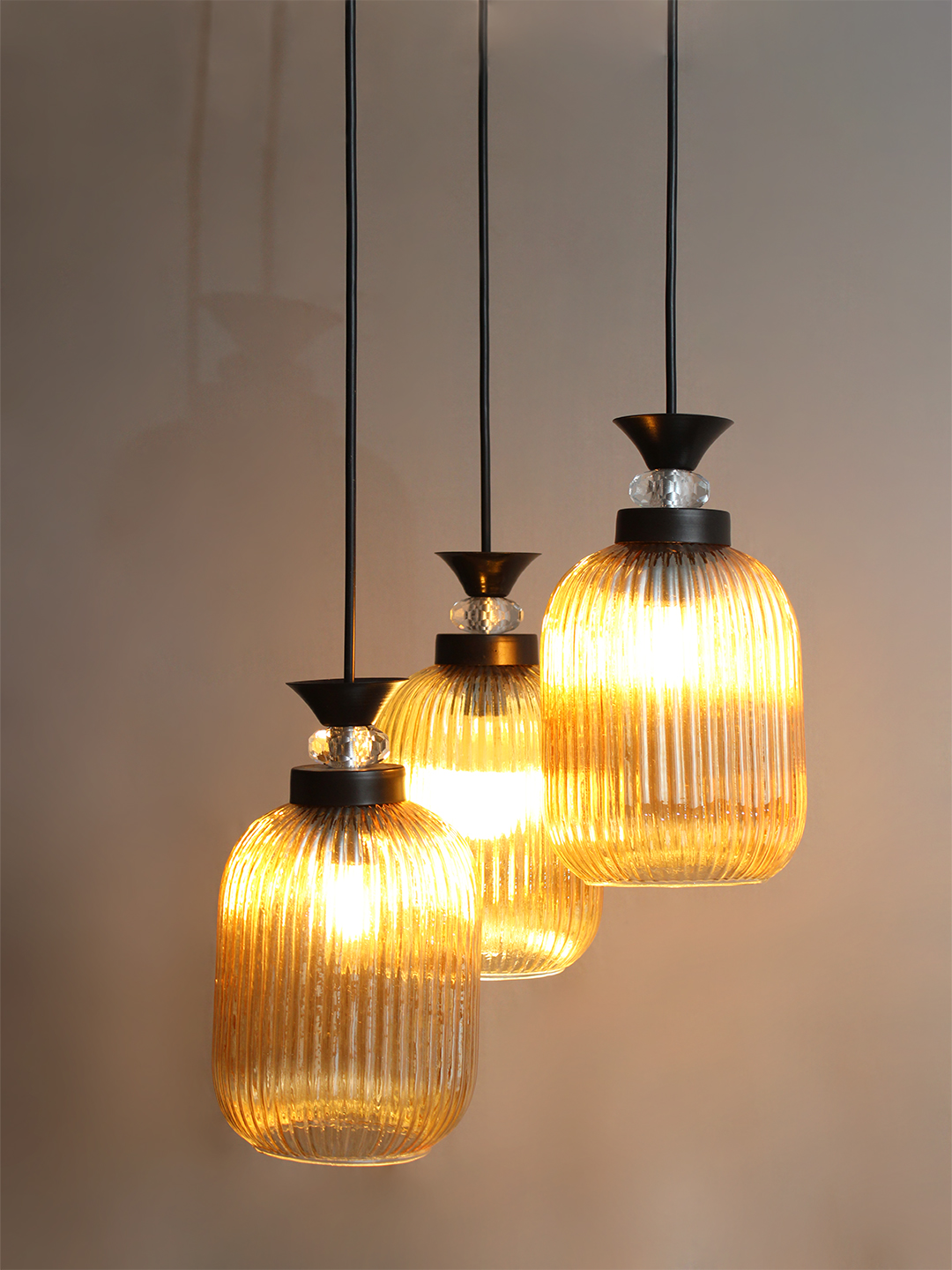 Decorative 3-Light Cluster Hanging Light Decorative 3-Light cluster hanging light with three amber ribbed glass shades and black adjustable ceiling mount.