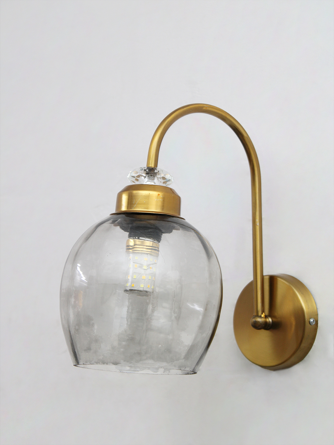 Antique Brass Smoked Glass Wall Sconce Antique brass smoked glass wall light with curved arm and round wall mount